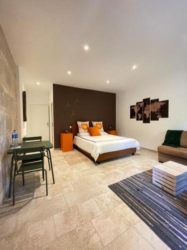 a bedroom with a bed and a table and a couch at Mas Tareau Chambres d Hotes in Beaucaire