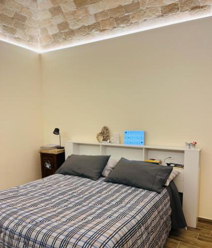a bedroom with a bed with a striped blanket at La casa del tempo in Vittorito