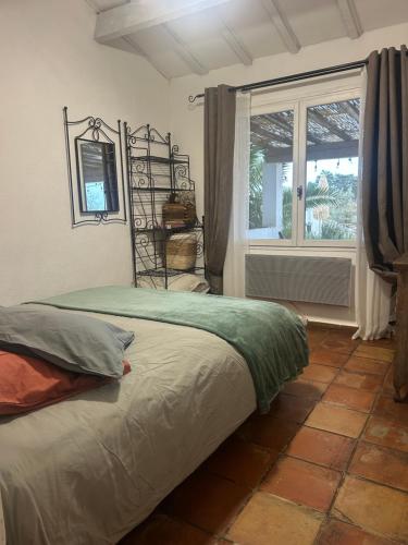 a bedroom with a bed in front of a window at Gite Armieux in Saintes-Maries-de-la-Mer