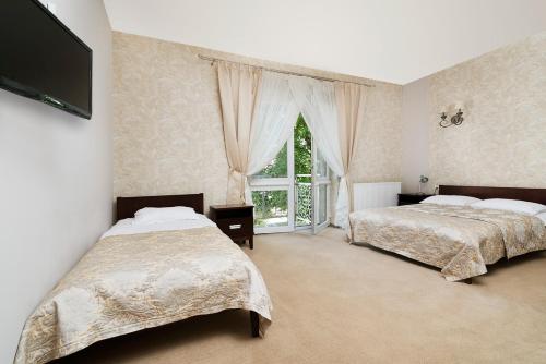 a bedroom with two beds and a window at Hotel Pod Kasztanami in Lublin