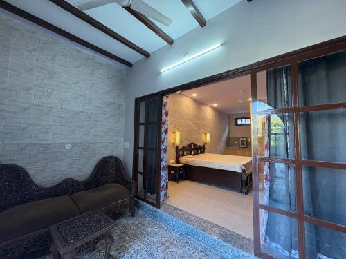 a bedroom with a bed and a sliding glass door at The Doghouse in Dehradun