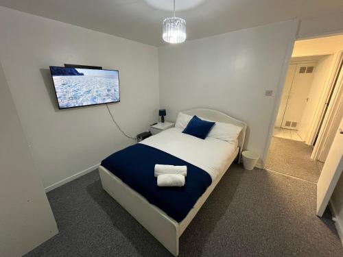 a bedroom with a bed with blue and white sheets and a tv at 3 bedroom Luxurious Property in Manchester