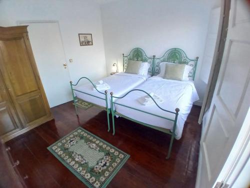 a white bed in a room with a wooden floor at Casa Kilowatt - Amarante in Amarante