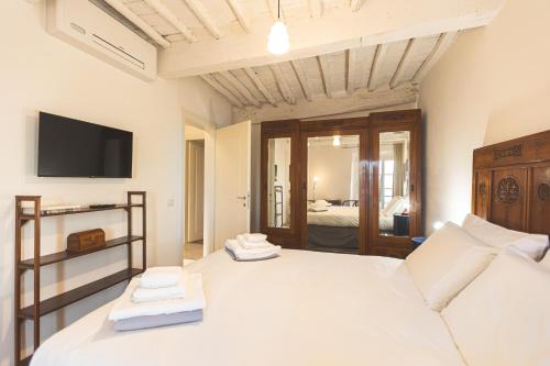 a bedroom with a large bed with a tv on the wall at Collazzi 15 in Montepulciano