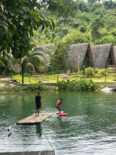two people on a bamboo raft in the water at Vangvieng Angsavanh Resort in Vang Vieng