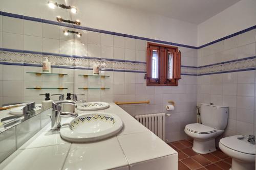 a bathroom with two sinks and a toilet at LuxRural Montserrat | Piscina con Vistas Únicas in Marganell