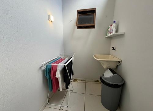 a small bathroom with a toilet and a trash can at Kitnet Econômica e Funcional in Campo Grande