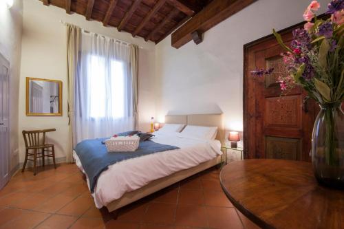 フィレンツェにあるCedar Pepiのベッドルーム1室(ベッド1台、花瓶付きのテーブル付)