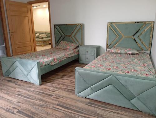 two beds in a room with a mirror at Private & Cozy 2 & 3 Bedroom Full Apartment for Families, Couples & Solo Near Islamabad Airport in Islamabad