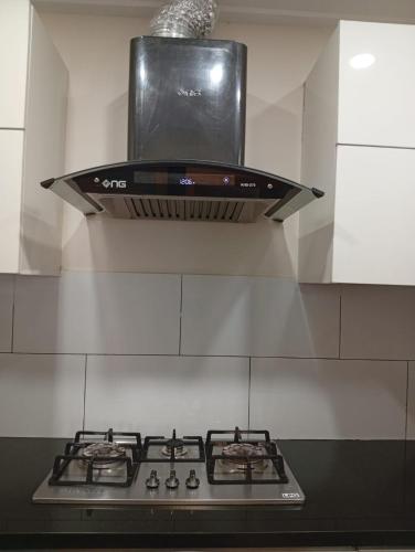 a stove top oven with a microwave above it at Private & Cozy 2 & 3 Bedroom Full Apartment for Families, Couples & Solo Near Islamabad Airport in Islamabad