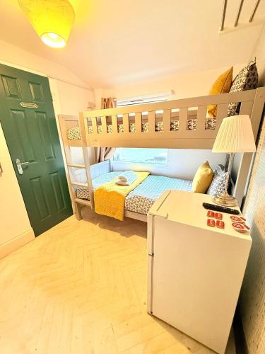 a small room with a bunk bed and a refrigerator at 10 Minutes to Central London Vaux in London