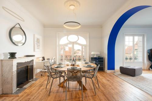 a dining room with a table and chairs and a fireplace at MISVA KEYWEEK Architect-designed flat in Biarritz with garden in Biarritz