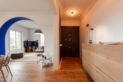 a living room with an archway and a living room with a couch at MISVA KEYWEEK Architect-designed flat in Biarritz with garden in Biarritz