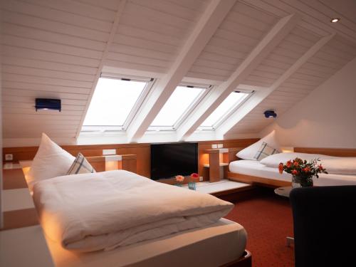 a bedroom with two beds in a room with skylights at Hanseat in Helgoland
