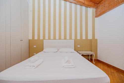 a bed in a room with a striped wall at Mansarda in Piazza Duomo in Milan