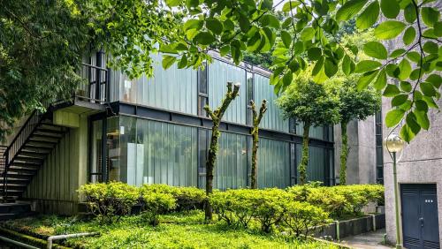 a building with glass windows and plants in front of it at Minami Hakone Villa in Kannami