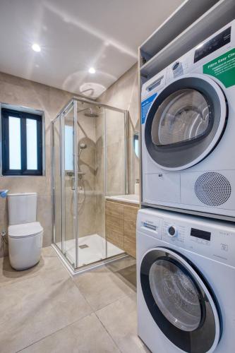 a washer and dryer in a bathroom with a shower at Seafront 3 Bedroom Luxury Getaway in St. Paul's Bay
