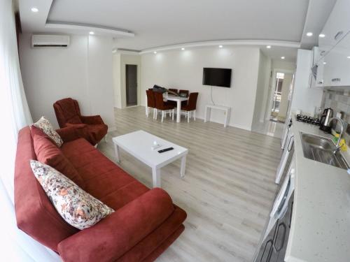 a living room with a red couch and a table at Taner Berk Apart 4 in Antalya