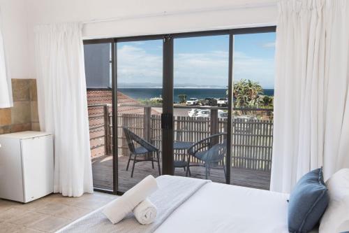 a bedroom with a bed and a view of the ocean at 3 Pepper Street by African Perfection in Jeffreys Bay
