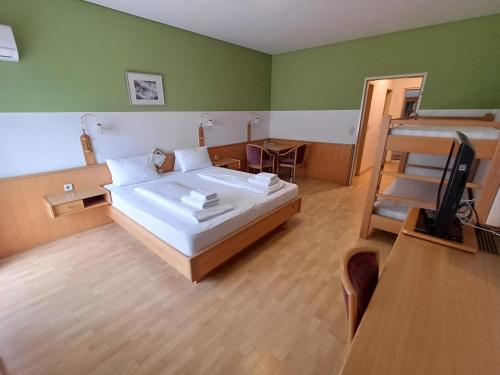 ein Schlafzimmer mit einem Bett und einem Fernseher in der Unterkunft Georgshof in Podersdorf am See