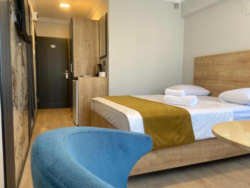 a bedroom with two beds and a blue chair at Güven Suit Otel in Istanbul