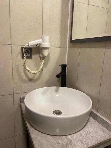a white sink in a bathroom with a phone at Güven Suit Otel in Istanbul