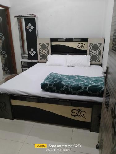 a bed in a room with a green blanket on it at Radha Rani homestay in Vrindāvan