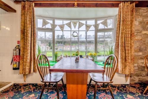 a dining room with a table and chairs and a large window at The Barn Guest House and Tearoom in Hutton le Hole