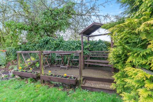 a wooden table and bench in a garden at The Barn Guest House and Tearoom in Hutton le Hole
