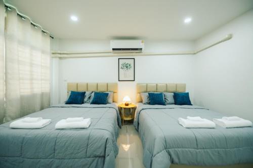 two beds in a room with blue pillows at 11 House - 9 mins drive to LeeGarden,parking available in Ban Kohong
