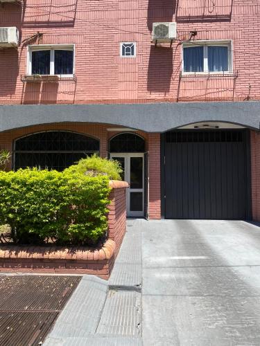 a red brick building with a black garage at Apartamento en zona centro de Asunción - tranquilo y con acceso directo in Asunción