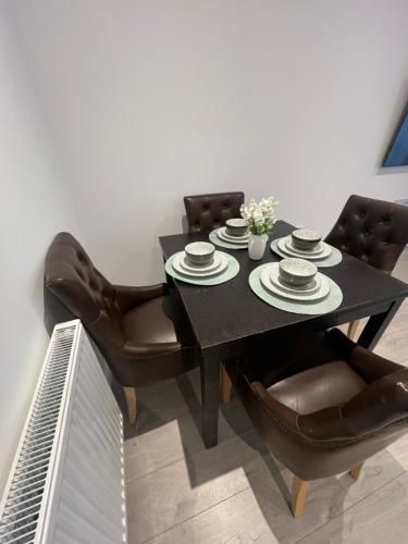 a black dining room table with leather chairs at Modern 3 Bedroom House in Hornchurch in Hornchurch