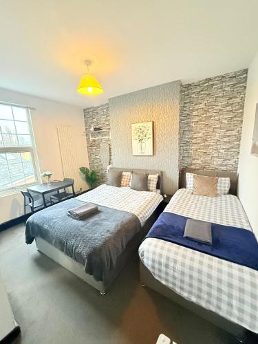 a room with two beds and a table with a table at 10 Minutes to Central London Vaux in London