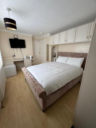 a bedroom with a large bed and a desk at Hawkins Guesthouse in Milton