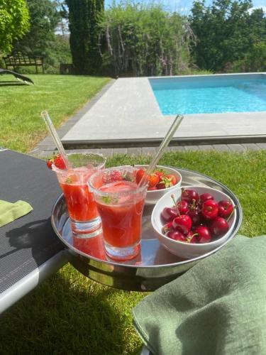 a tray with two drinks and a bowl of fruit at Schiller Ferienwohnung, Pool, Nideggen, Eifel in Nideggen