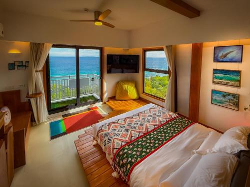 a bedroom with a bed with a view of the ocean at Aqua Horizon Art Studio Condo in Dauis