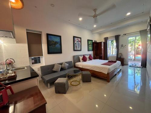 a large bedroom with a bed and a couch at Red House Homestay - Villa in Hoi An