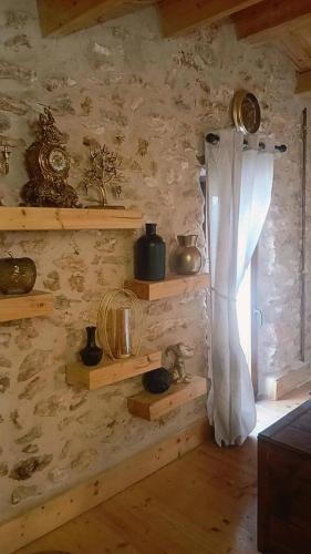 a room with wooden shelves and a window with a curtain at La Casita de Lledó in Vilafamés
