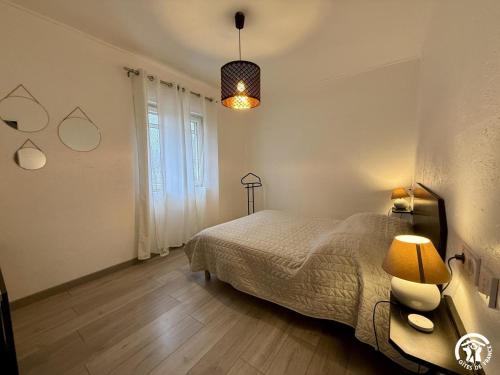 a bedroom with a bed and a table and a lamp at Les ferrajals in Rouvenac