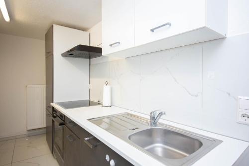 a kitchen with a sink and white cabinets at Mimi's Home in Dußlingen