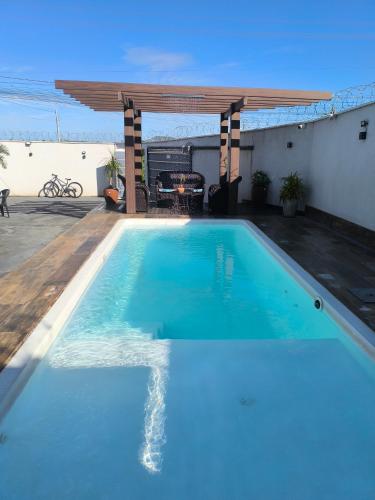 a large blue swimming pool with a pergola at Espaço de eventos dorneles in Senador Canedo