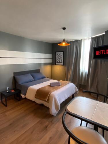a bedroom with a bed with blue pillows and a table at Bright Studio Apartment Casa Icacos Apt 3 in Mexico City