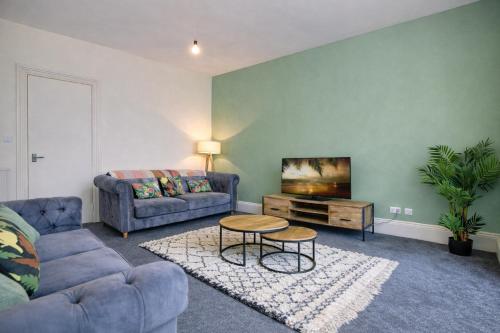 a living room with a couch and a table at Group Stay 4BR Sleeps 11 Spacious with Parking in Glasgow