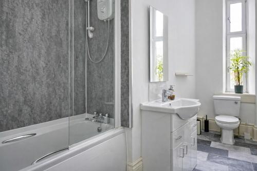 a bathroom with a shower and a sink and a toilet at Group Stay 4BR Sleeps 11 Spacious with Parking in Glasgow