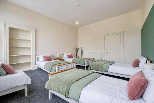 three beds in a room with green and white at Group Stay 4BR Sleeps 11 Spacious with Parking in Glasgow
