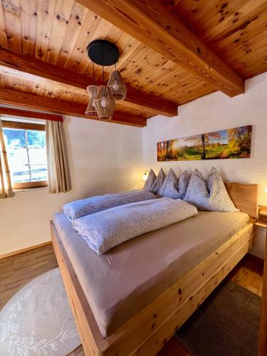 a bedroom with a large bed with wooden ceilings at Umundumhütte in Katsch an der Mur