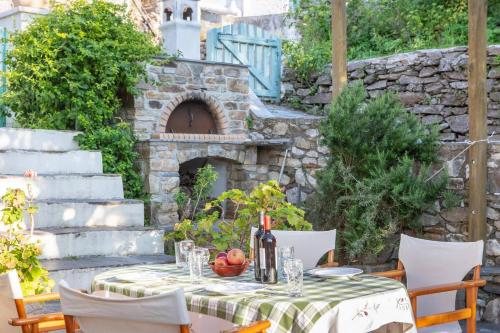 an outdoor patio with a table and a stone oven at Villa Matakia in Áno Potamiá