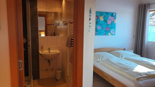 a bedroom with a bed and a sink and a bathroom at Lindenhaus in Zwiesel