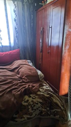 a bedroom with a bed and a wooden cabinet at Tetelos house in Cullinan
