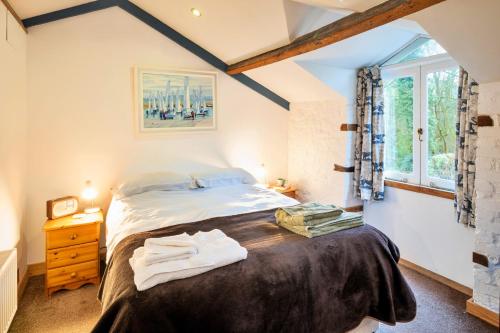 a bedroom with a bed and a window at Finest Retreats - Little Roost in Lyme Regis